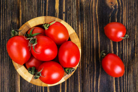 Red tomatoes in wooden salad bowlの写真素材