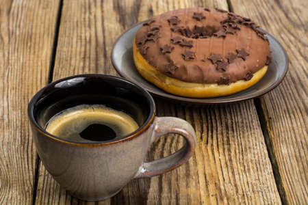 One donut in chocolate glaze on wooden backgroundの写真素材
