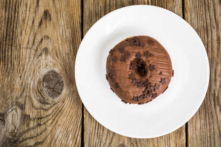 One donut in chocolate glaze on wooden backgroundの写真素材