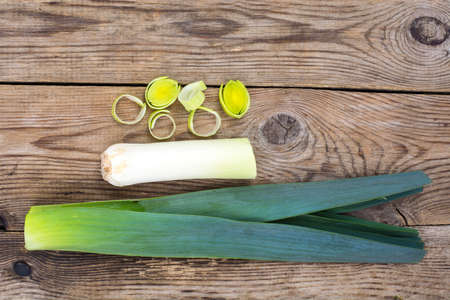 Leek, cut into pieces, on an old wooden tableの写真素材