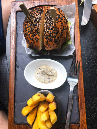 Fastfood: fries, sauce, hamburger with black seedsの写真素材