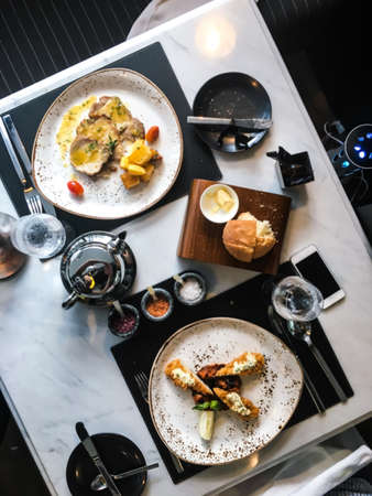 Baked potatoes and slices of beef in sauceの写真素材