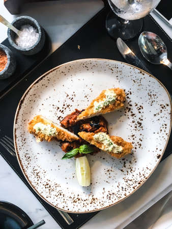 Chicken fillet in breadcrumbs with sauce and vegetablesの写真素材