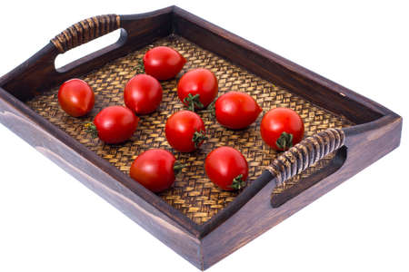 Brown wooden tray with small red tomatoes. Studio Photoの写真素材