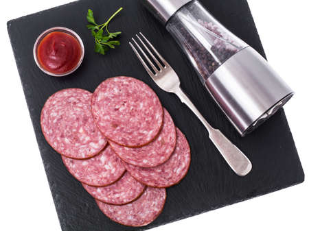 Sliced sausage on black stone plate. Studio Photoの写真素材