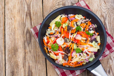 Frozen cooked vegetable mix in frying pan on wooden background,の写真素材