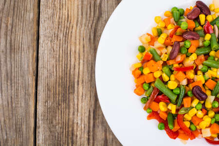 Boiled vegetables in white plate on old wooden table. Healthy veの写真素材