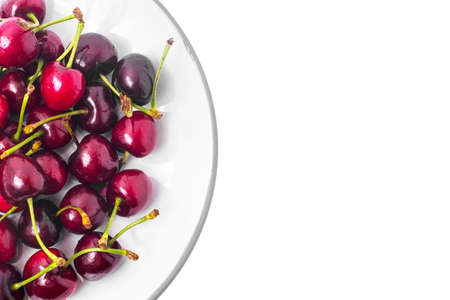 Seasonal fruit: aromatic sweet ripe cherry in plate isolated onの写真素材