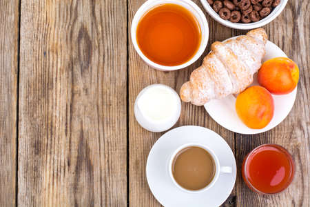 Chocolate cereal flakes, coffee, milk, croissant and fruit for bの写真素材