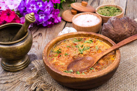Village soup in wooden bowl on an old tableの写真素材