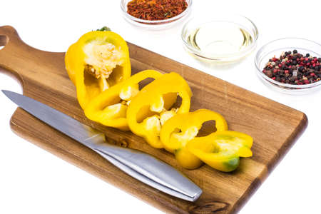 Yellow sweet pepper, slices cut, on kitchen wooden cutting board. Studio Photoの写真素材