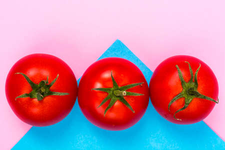 Pastel bright background with red tomatoesの写真素材