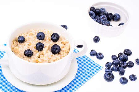 Healthy food. Oatmeal porridge with blueberries on blue napkinの写真素材