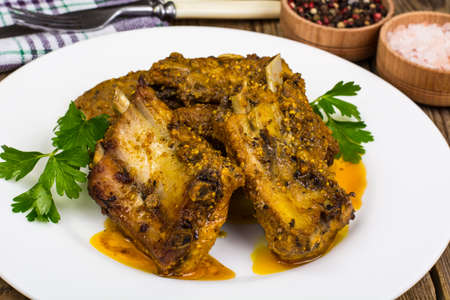 Spicy meat ribs in mustard sauce on wooden tableの写真素材