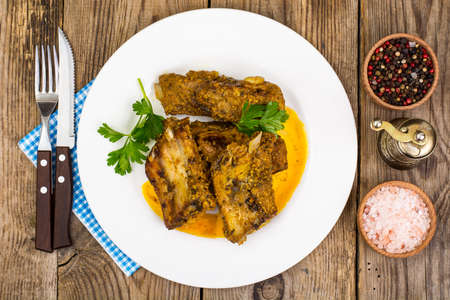 Spicy meat ribs in mustard sauce on wooden tableの写真素材