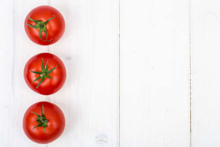 Red tomatoes on white wooden backgroundの写真素材