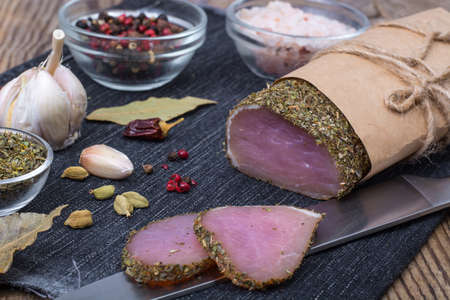 Smoked ham on wooden table with aromatic herbs and spices, natural productの写真素材