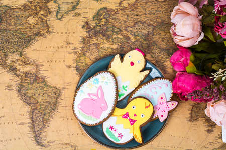 Easter  holiday travel on different countries. Beautiful glazed cookies, world mapの写真素材
