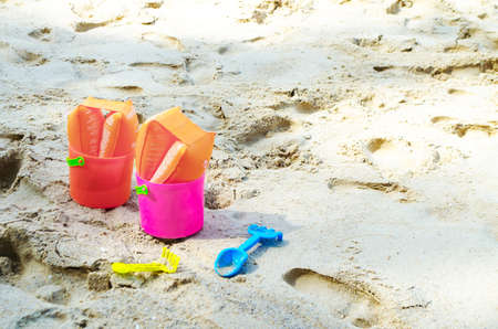 Baby plastic bucket with toys on sandy seasideの写真素材