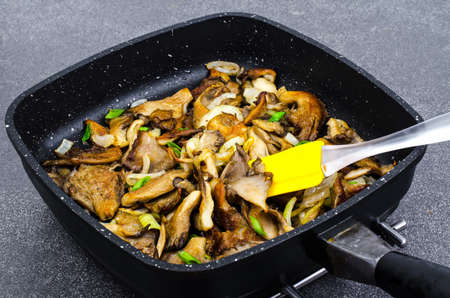 Oyster mushrooms fried with onions in frying panの写真素材