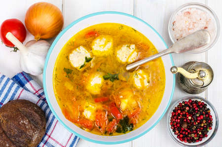 Plate of soup with meatballs on white wooden tableの写真素材