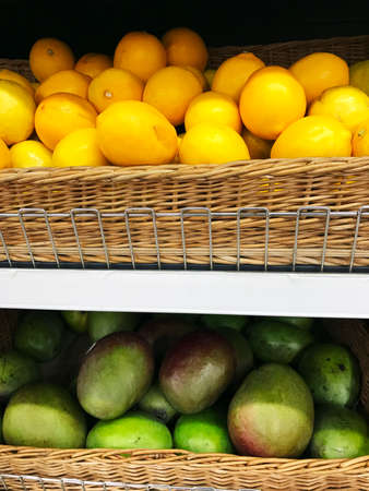 Lemons and green mango in wicker baskets in supermarket. Studio Photoの写真素材