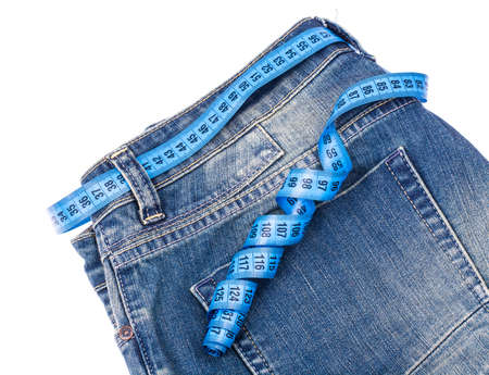 Concept of healthy lifestyle, weight loss. Jeans with measuring tapeの写真素材