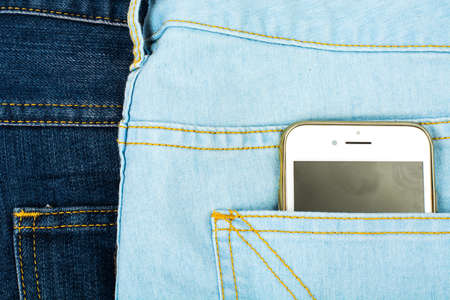 Mobile phone in the pocket of the blue jeansの写真素材