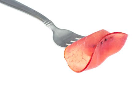 Slice of smoked ham on forkの写真素材