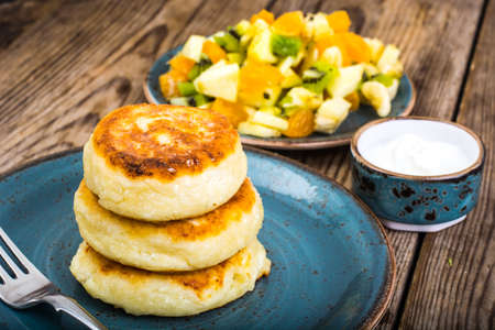 Hot delicious curd pancakes with fruit salad and yogurt. Studio Photoの写真素材