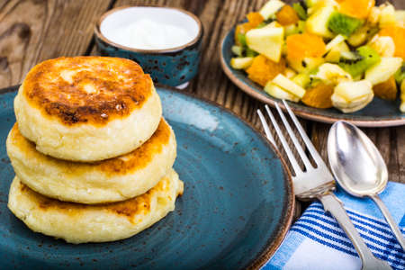 Hot delicious curd pancakes with fruit salad and yogurt. Studio Photoの写真素材