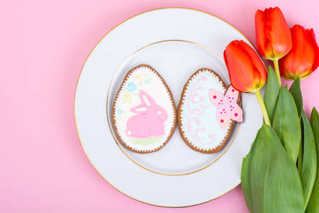Easter gifts, sweet gingerbreads, flowers on pastel background