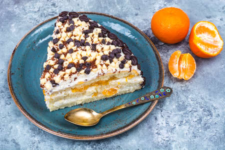 Delicious piece of cake with fruit, whipped cream and chocolate dropsの写真素材