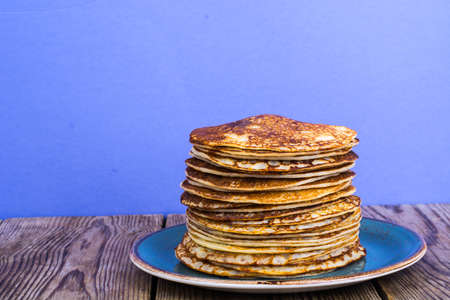 Stack of hot delicious pancakes on bright violet backgroundの写真素材