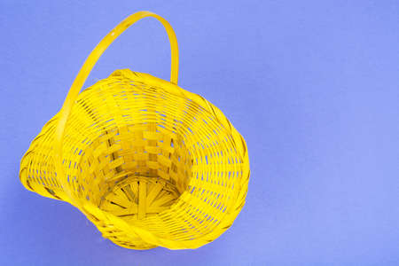 Preparation for Easter. Yellow basket with chicken eggs on violet backgroundの写真素材