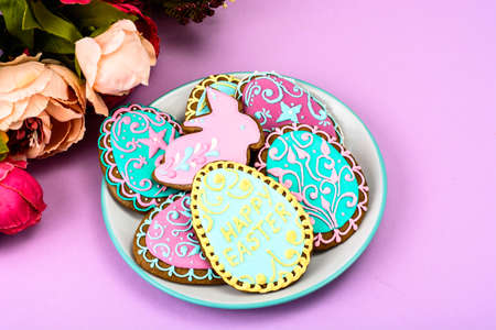 Easter homemade baked gingerbread cookies in the form of eggs with different pattern of icing on plateの写真素材