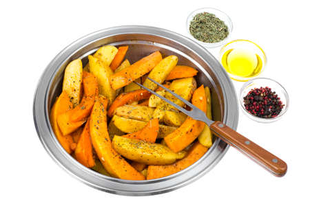 Raw potato slices and pumpkin with spices in metal bowlの写真素材