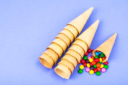 Crispy waffle cones with colorful candiesの写真素材