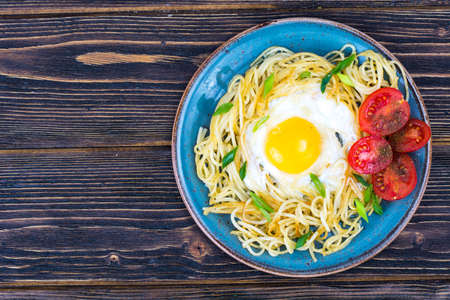 Breakfast. Spaghetti, fried egg, tomatoesの写真素材