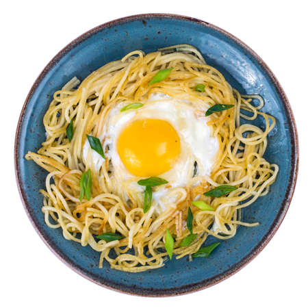 Blue plate with spaghetti, fried egg on white backgroundの写真素材