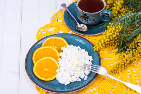 Concept of healthy dietary nutrition. Fresh raw cottage cheese with fruit, herbal teaの写真素材