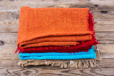 Stack of colored  burlap on wooden tableの写真素材