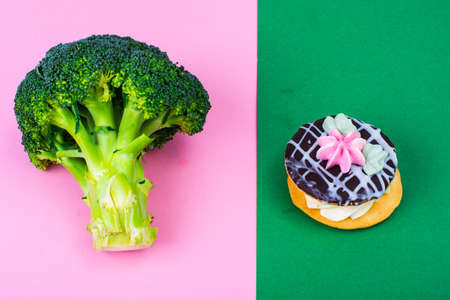 Choosing between broccoli and unhealthy food, cake bush. Concept of vegetarianism and healthy...