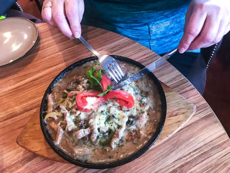 Hot pan with potatoes, meat, gravy and tomatoes. Studio Photoの写真素材