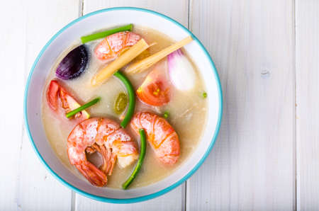Spicy soup with prawns on coconut milk. Studio Photo