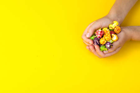 Colorful popcorn in children's hands. Studio Photo