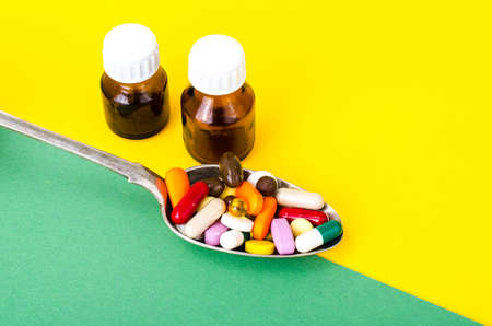 Tablets, capsules, pills in spoon on bright background. The concept of medicine and healthの写真素材
