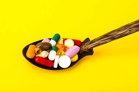 Tablets, capsules, pills in spoon on bright background. The concept of medicine and health. Studio...