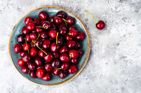 Ripe burgundy cherry in bowl on table. Studio Photoの写真素材