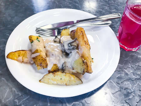 Potato slices with mushroom sauce, fruit juice